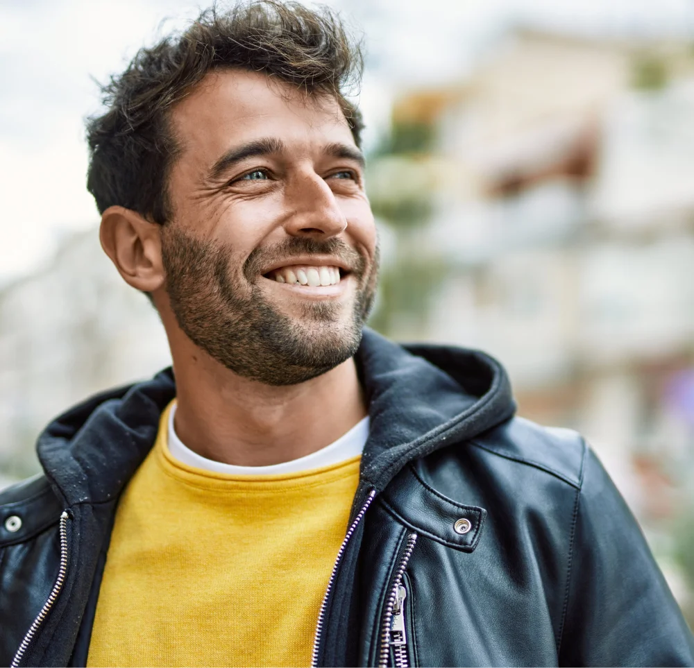 smiling man in yellow sweater and leather jacket