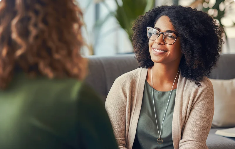 woman with glasses smiles while talking about olympia grove recovery with her therapist