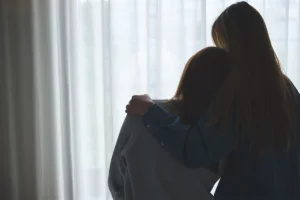 Silhouette of two women comforting each other over withdrawal symptoms