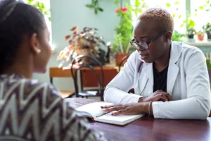 Doctor in plant filled room explaining treatment paperwork to patient